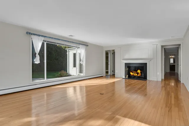 wooden floor fireplace and windows in an empty room