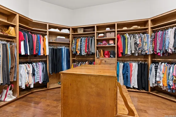 a view of walk in closet with clothes and shoes