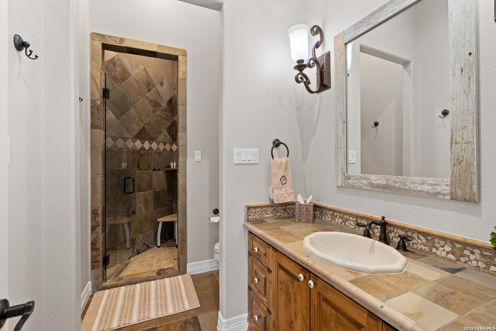 136 Park Ridge Boerne, TX 78006 - Photo 28 of 47 a bathroom with a granite countertop sink a mirror a vanity and shower