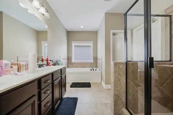 a bathroom with a tub sink and mirror
