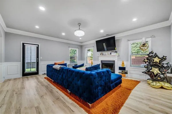 a living room with furniture a fireplace and a flat screen tv