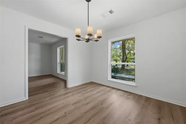a view of a room with wooden floor a ceiling fan and a bathroom