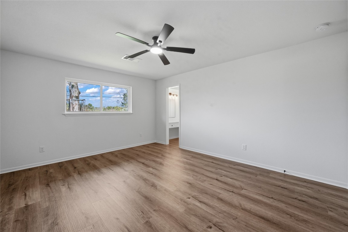 210 Ridgemont Drive Alvin, TX 77511 - Photo 15 of 25 a view of empty room with wooden floor and fan