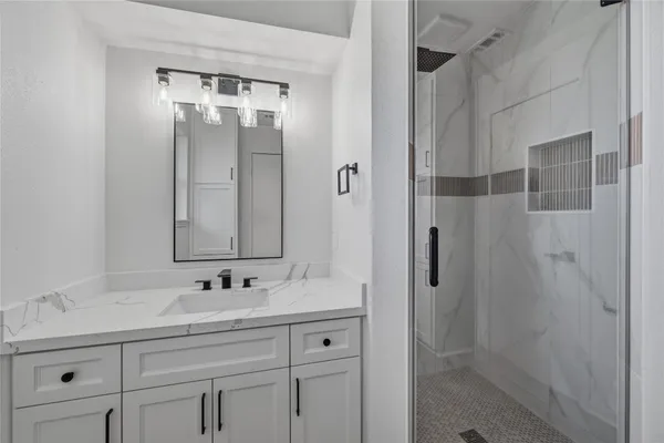 a bathroom with a shower sink and mirror
