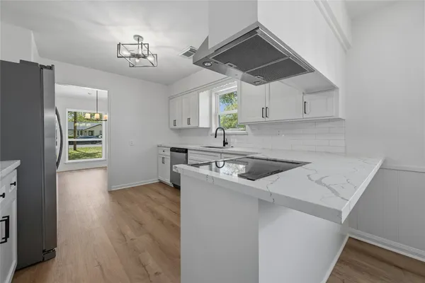 a kitchen with a sink a stove a refrigerator and cabinets