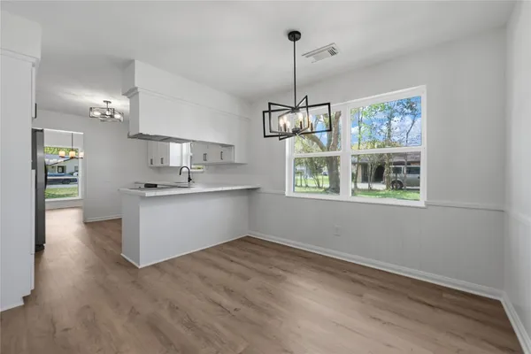 a kitchen with stainless steel appliances kitchen island a wooden floor and window