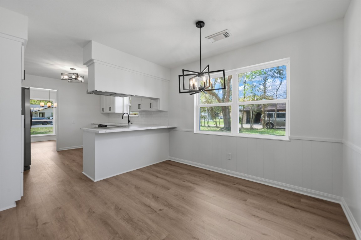 210 Ridgemont Drive Alvin, TX 77511 - Photo 7 of 25 a kitchen with stainless steel appliances kitchen island a wooden floor and window