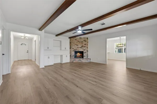 a view of a livingroom with wooden floor and furniture