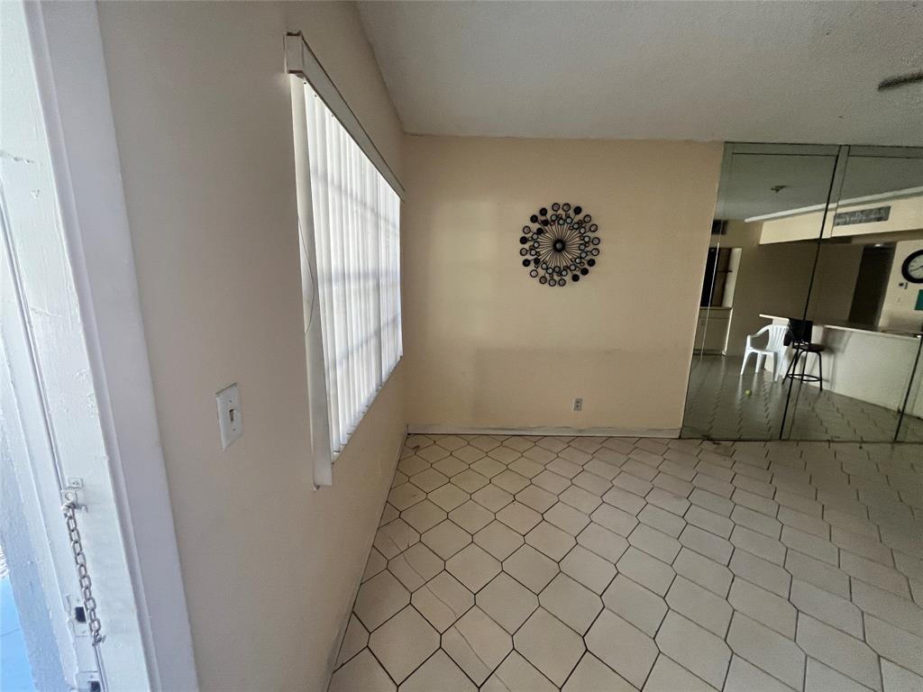 751 Pine Drive, Unit 103 Pompano Beach, FL 33060 - Photo 7 of 18 an empty room with windows