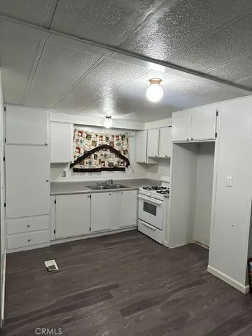 a kitchen with a stove cabinets and wooden floor