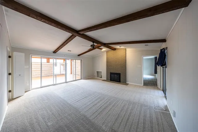 a view of an empty room with a fireplace and a window