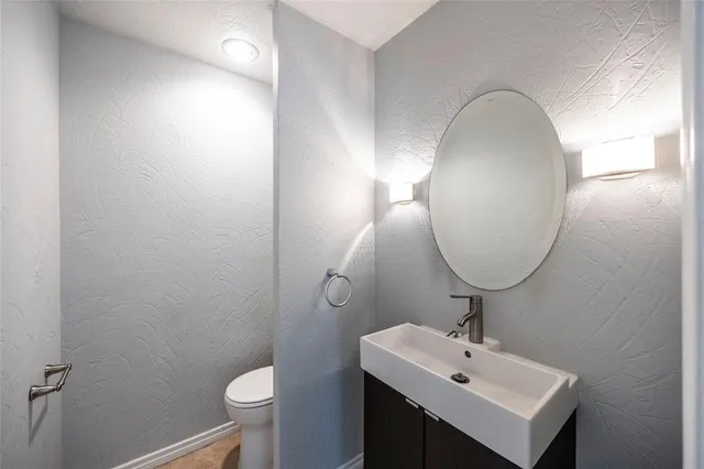 a bathroom with a sink mirror and toilet