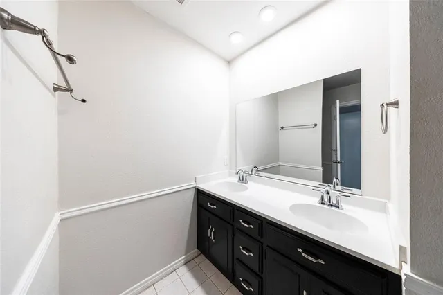 a bathroom with a double vanity sink and a mirror