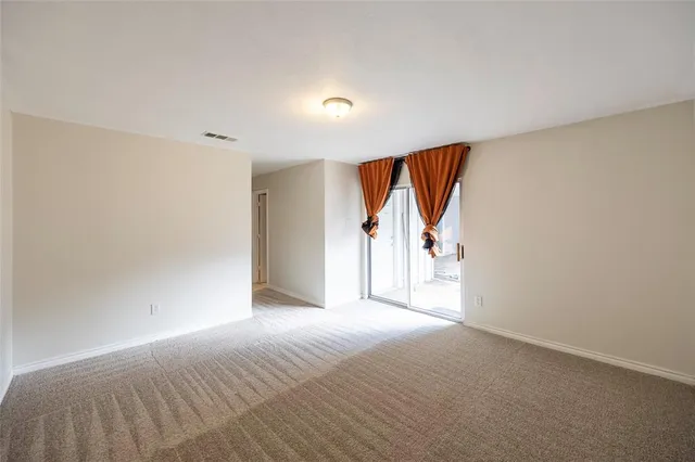 a view of a room with a ceiling fan and window