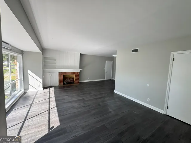 an empty room with wooden floor and fireplace