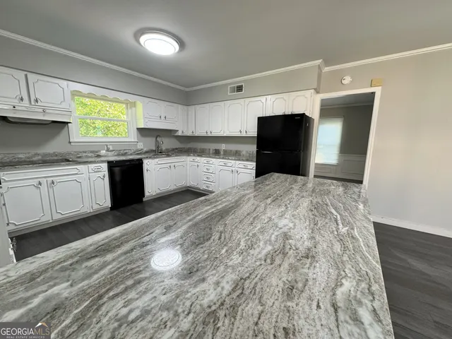 a kitchen with granite countertop a stove a sink and a microwave