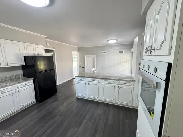 a kitchen with granite countertop a refrigerator stove and sink