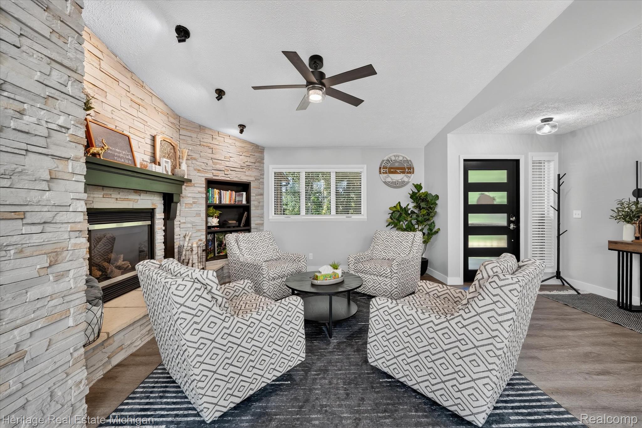 1888 Germany Road Williamston, MI 48895 - Photo 4 of 57 Modern living room anchored by a striking stacked-stone fireplace with built-in shelving and a linear fireplace insert