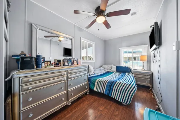 a bedroom with a bed and a flat tv screen on dresser