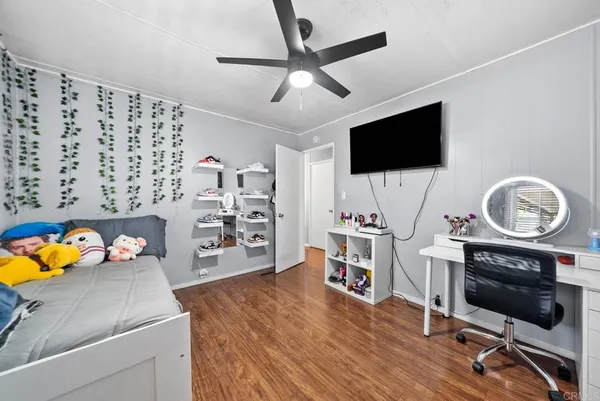 a view of a livingroom with workspace and a flat screen tv