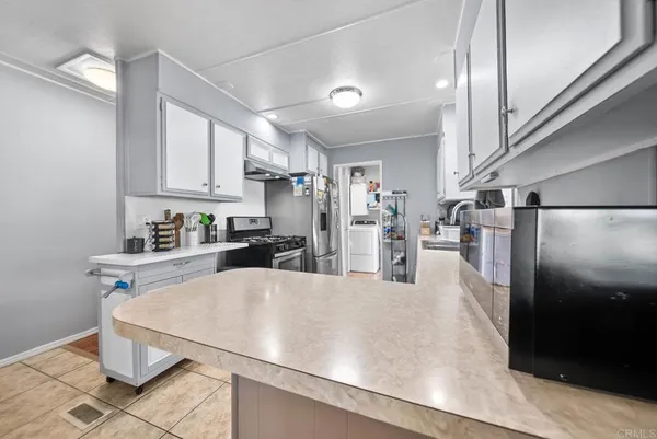 a kitchen with stainless steel appliances a refrigerator sink and cabinets