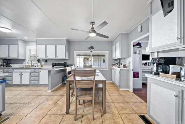 a kitchen with stainless steel appliances granite countertop a stove top oven a sink a dining table and chairs