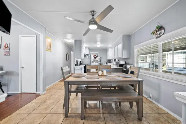 a dining room with stainless steel appliances kitchen island granite countertop a dining table chairs and a refrigerator
