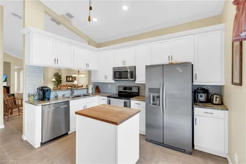 a kitchen with stainless steel appliances a refrigerator a sink a stove a microwave a sink and cabinets