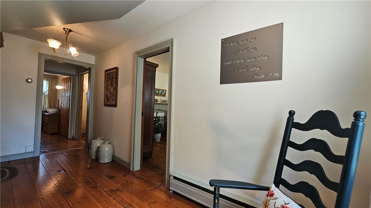 585 Buttermilk Road Hellertown, PA 18055 - Photo 30 of 82 Rich hardwood flooring guides you through this inviting interior hallway, illuminated by classic light fixtures.