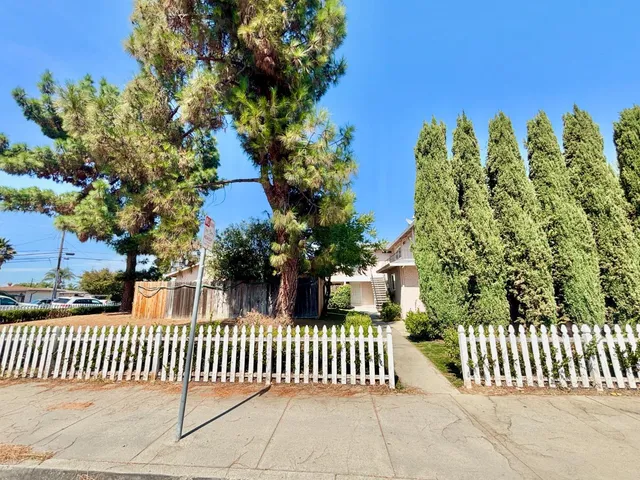 a view of a porch with plants and wooden fence