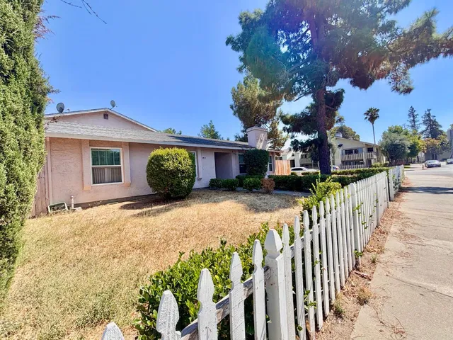 a view of a house with wooden fence