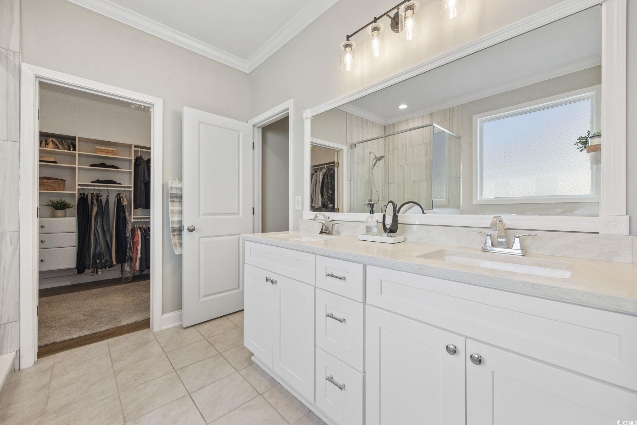 147 Hyacinth Loop Murrells Inlet, SC 29576 - Photo 14 of 40 Bathroom with a walk in closet, ornamental molding, double vanity, a shower stall, and light tile patterned floors