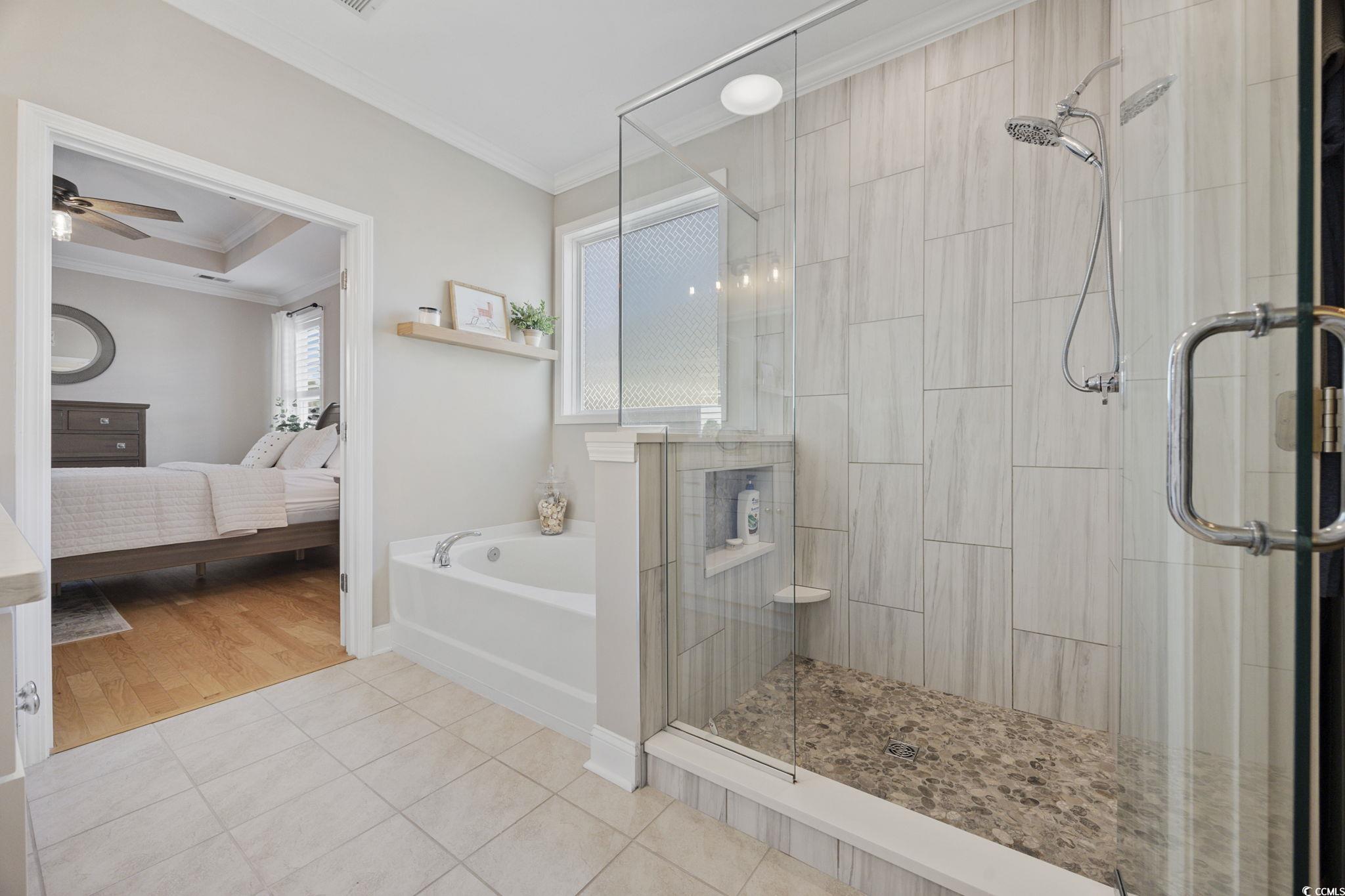 147 Hyacinth Loop Murrells Inlet, SC 29576 - Photo 15 of 40 Ensuite bathroom featuring crown molding, a bath, light tile patterned floors, a shower stall, and ceiling fan