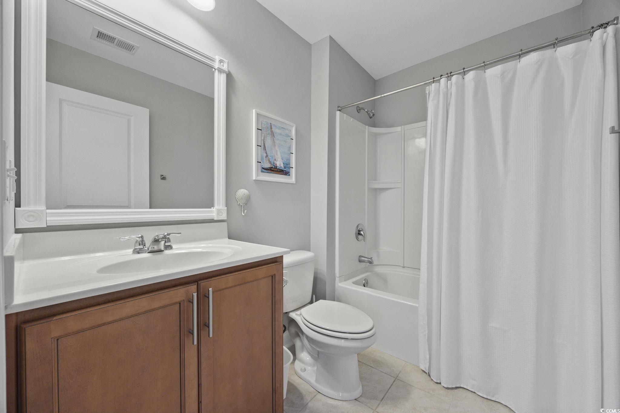147 Hyacinth Loop Murrells Inlet, SC 29576 - Photo 21 of 40 Bathroom featuring shower / tub combo with curtain, vanity, and light tile patterned flooring