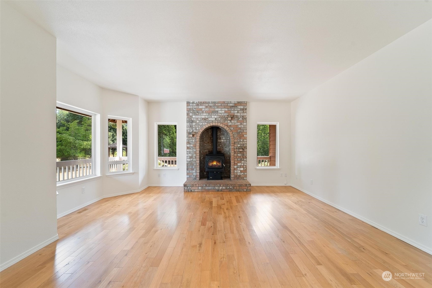 3321 Whiteman Road Southwest Longbranch, WA 98349 - Photo 12 of 40 a view of an empty room with wooden floor fireplace and a window