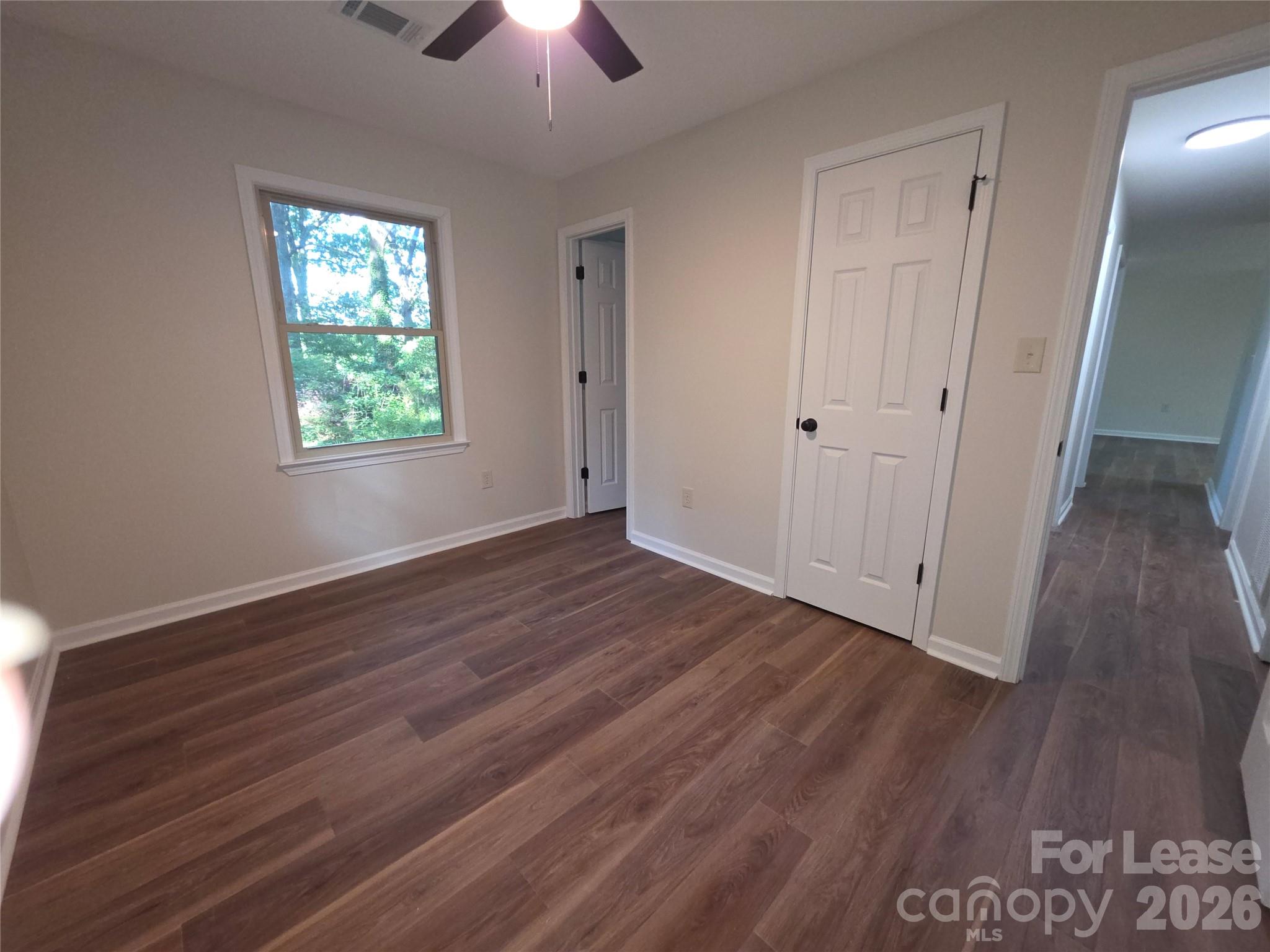 5710 Unionville Road Monroe, NC 28110 - Photo 13 of 18 an empty room with wooden floor chandelier fan and windows