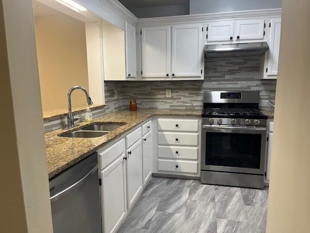 5950 WinterGreen Road Northwest Norcross, GA 30093 - Photo 20 of 33 a kitchen with granite countertop a stove sink and cabinets