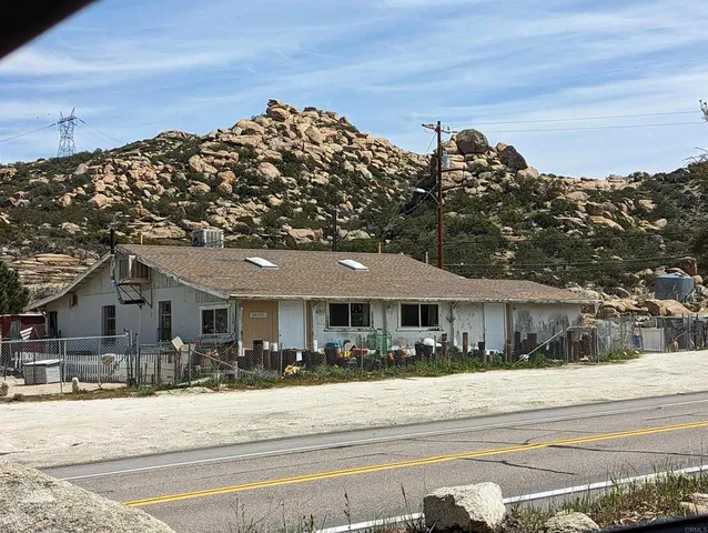 a view of a dry yard with mountains and green space
