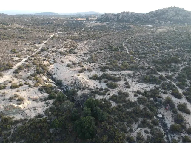 a view of a dry yard covered with snow in the background