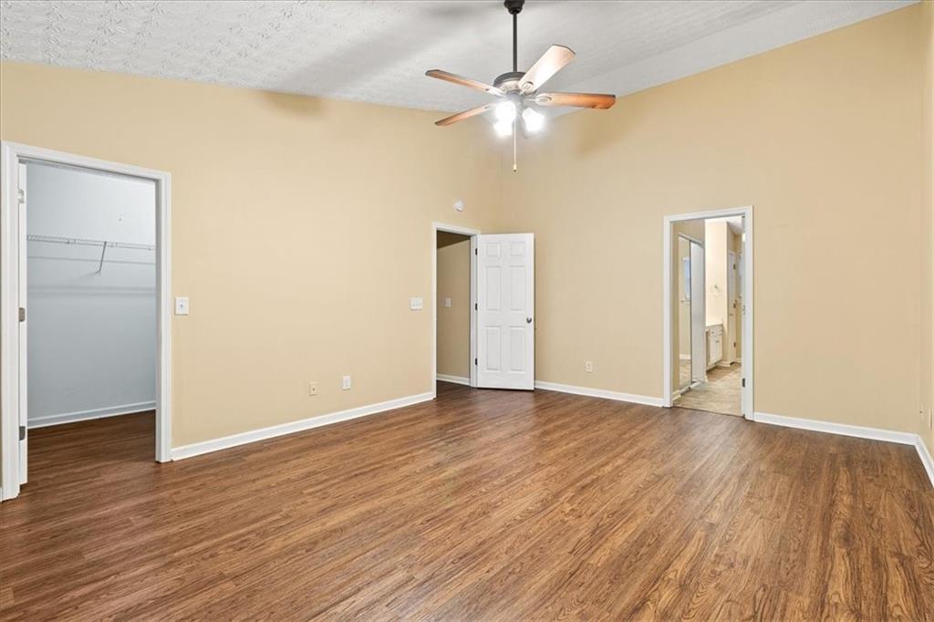 329 Meadows Lane Canton, GA 30114 - Photo 19 of 36 an empty room with wooden floor chandelier fan and windows