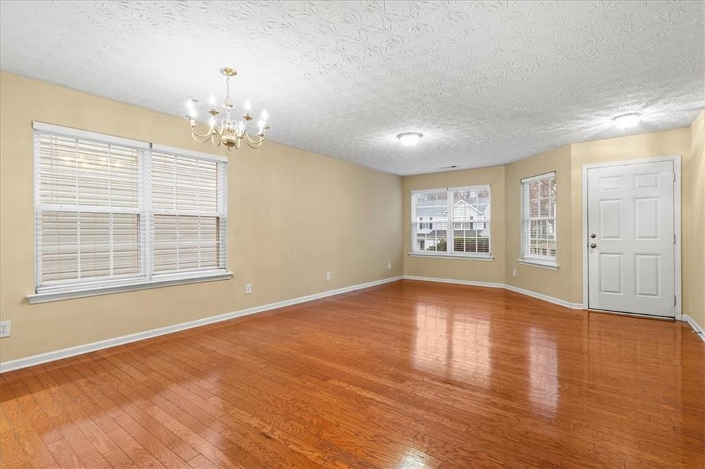 329 Meadows Lane Canton, GA 30114 - Photo 5 of 36 a view of an empty room with a window and wooden floor