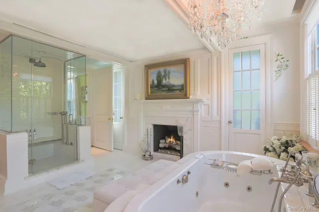 a spacious bedroom with a bed and a chandelier