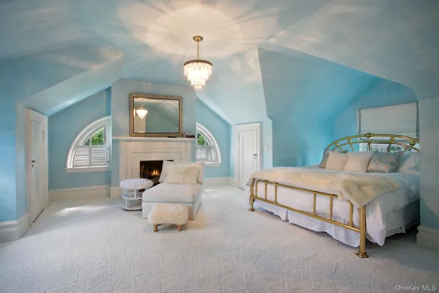 a spacious bedroom with a bed fireplace and window