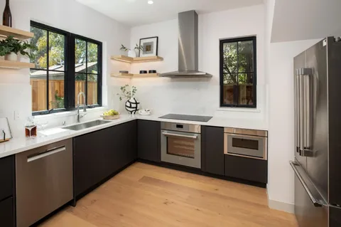 a kitchen with stainless steel appliances granite countertop a sink stove and refrigerator