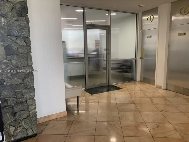a hallway with painting on the wall and a potted plant