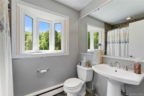 a bathroom with a sink a toilet and a window