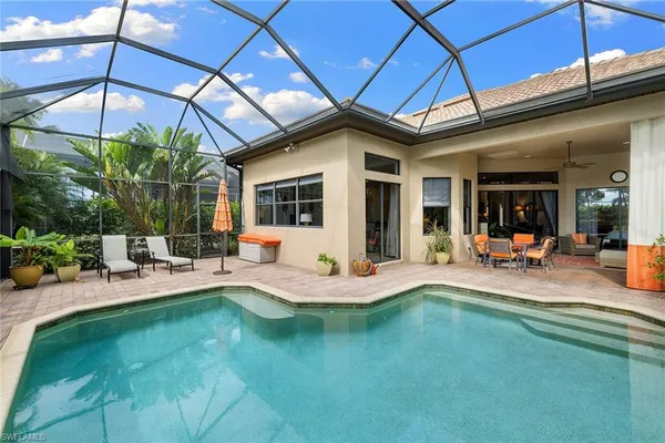 a view of a backyard with swimming pool and sitting area