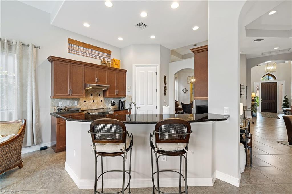 6513 Caldecott Drive Naples, FL 34113 - Photo 16 of 33 a kitchen with stainless steel appliances a stove a sink and a refrigerator