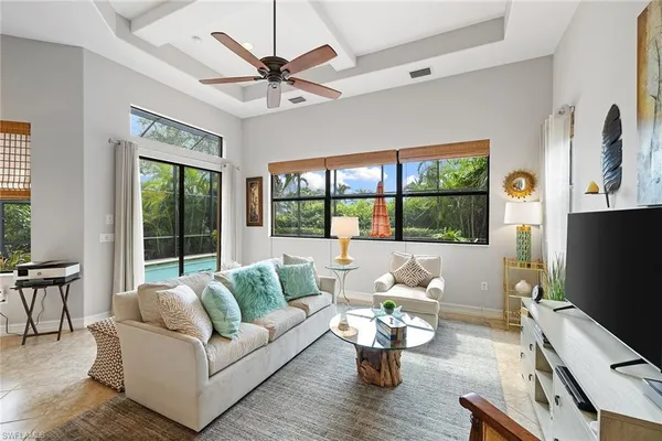 a living room with furniture flat screen tv and a large window