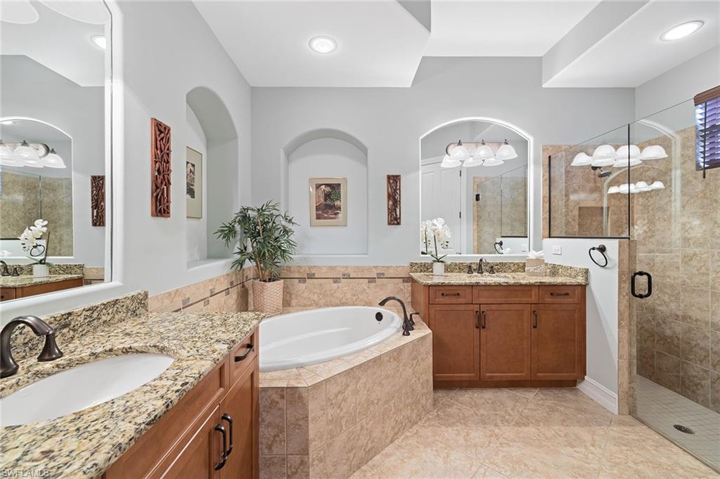 6513 Caldecott Drive Naples, FL 34113 - Photo 25 of 33 a bathroom with a granite countertop sink a large mirror and shower